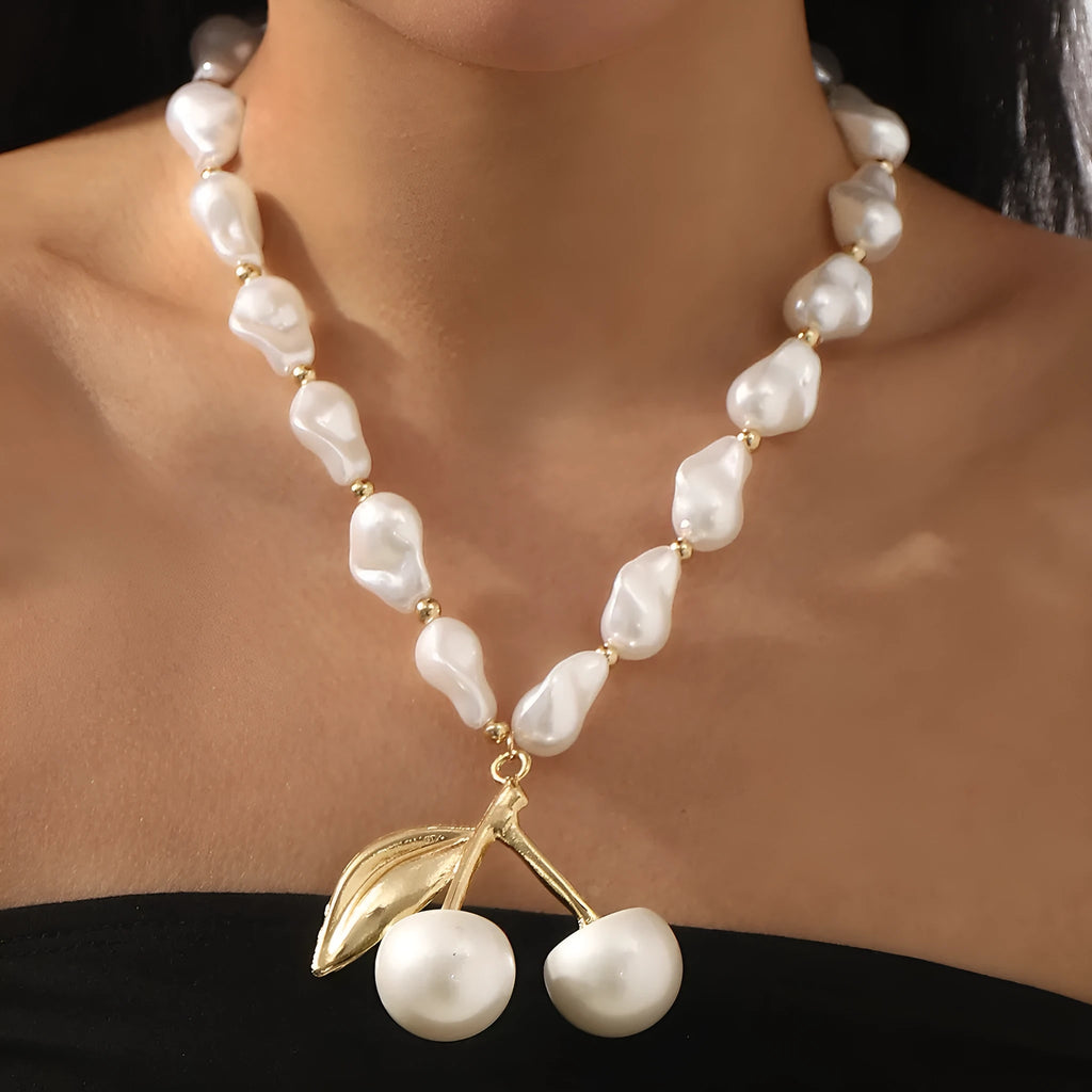Gold irregular cherry fruit pendant on an adjustable imitation pearl chain necklace for women.