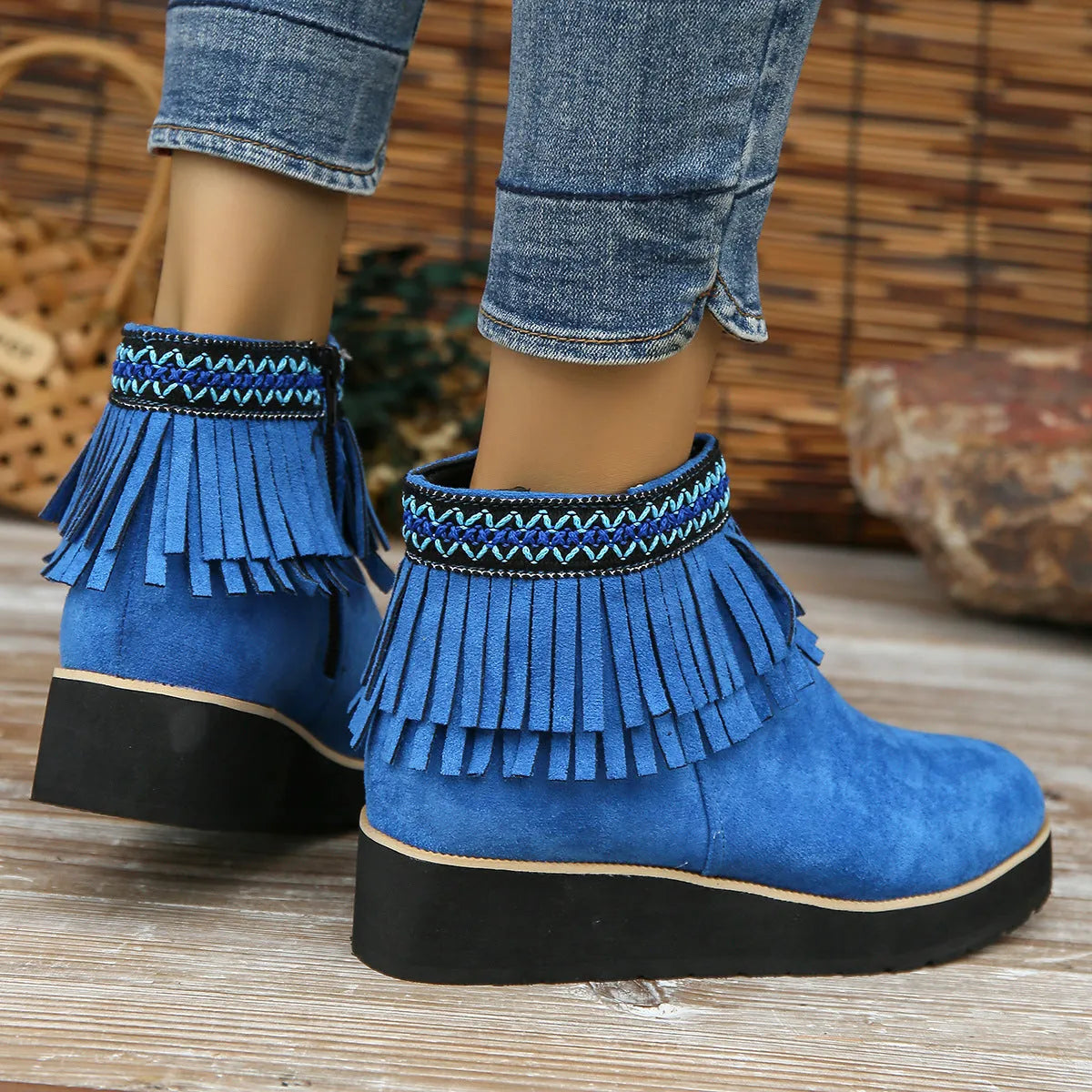 Women's dark brown suede ankle boots with a wedge heel, thick platform sole, tassel detail, and side zipper.