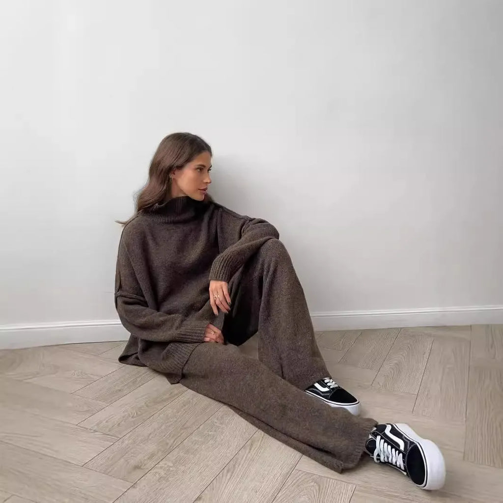Women's dark grey acrylic knit suit with side-slit hem sweater and matching trousers laid flat.