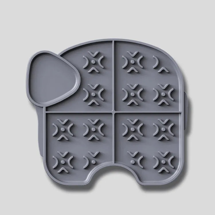 Gray silicone pet slow food pad with suction cups on tile floor, textured surface for licking
