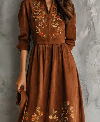 Brown suede-effect midi dress with detailed floral embroidery on the skirt, shown on a model.