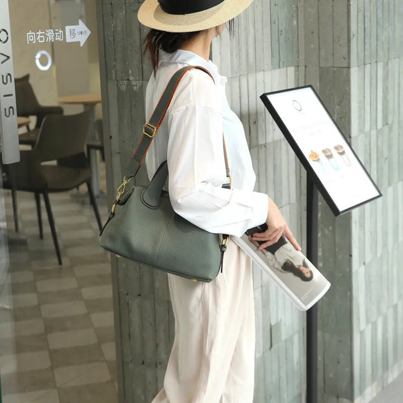 Black genuine leather women's cross-body shoulder bag with square shape and cross-body strap.