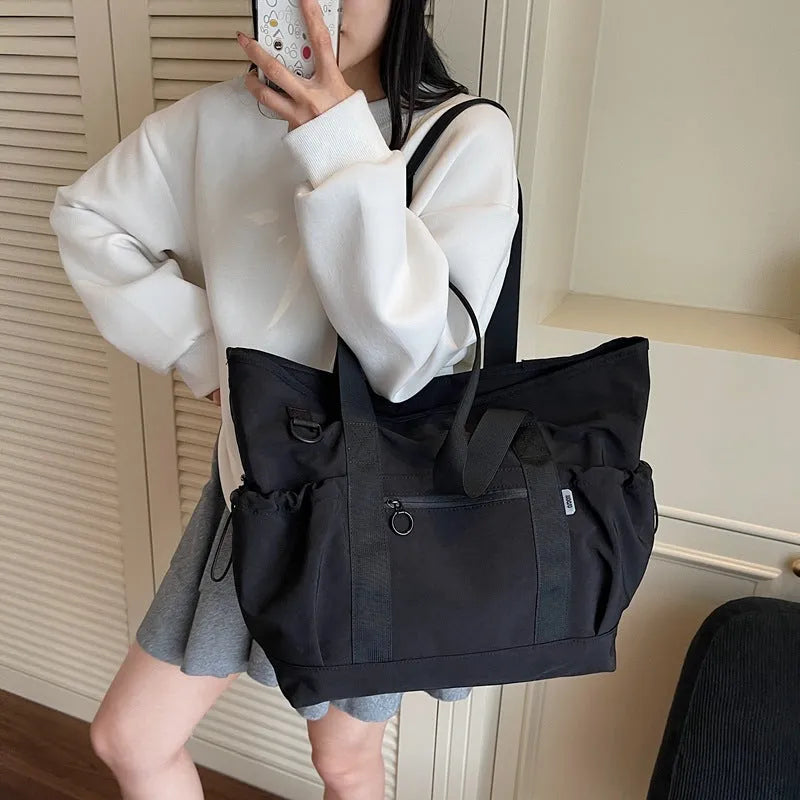 Lightweight Oxford cloth duffel bag for women in grey, shown with a yoga mat.