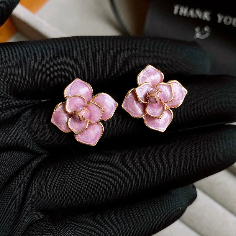 Gold plated purple oil-spot glaze 3D flower stud earrings with surgical steel posts on a white background.