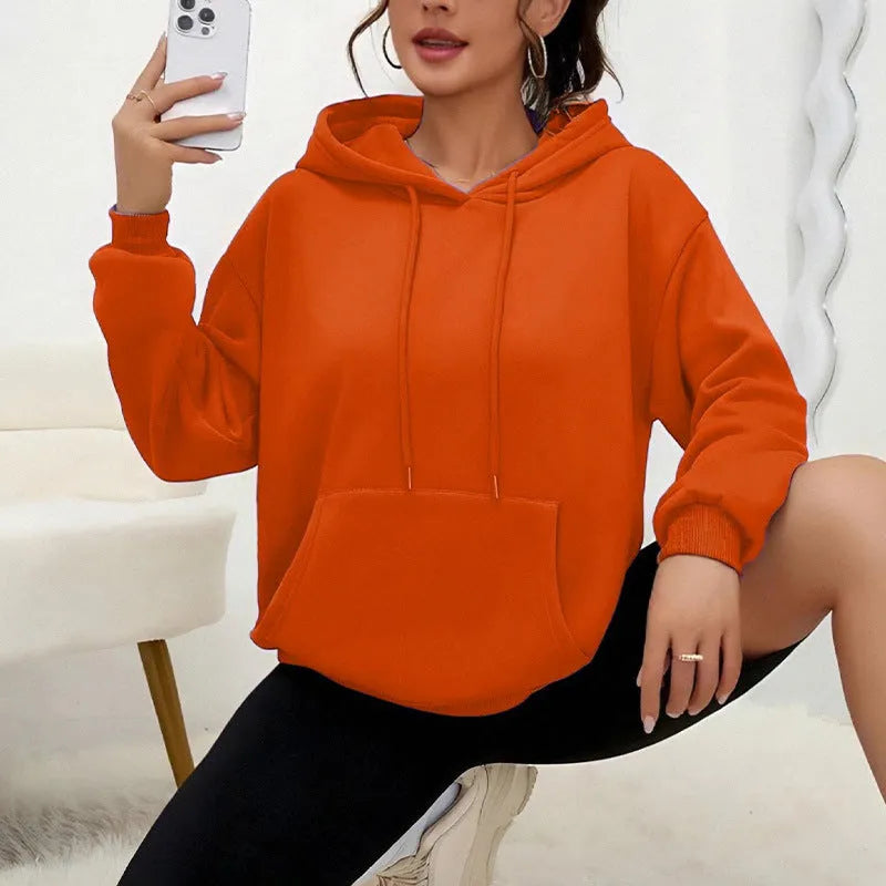 Women's loose grey drawstring pocket sweatshirt on a hanger showing front detail.