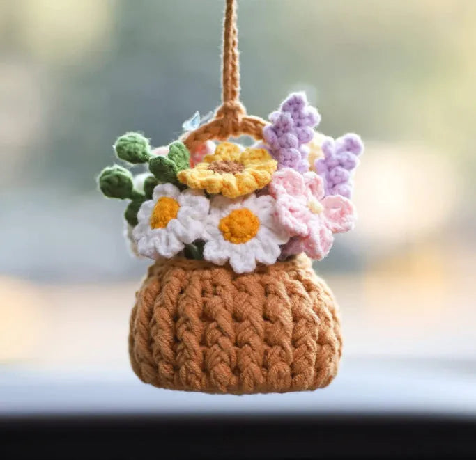 Green and white knitted wool car plant ornament hanging from a rope