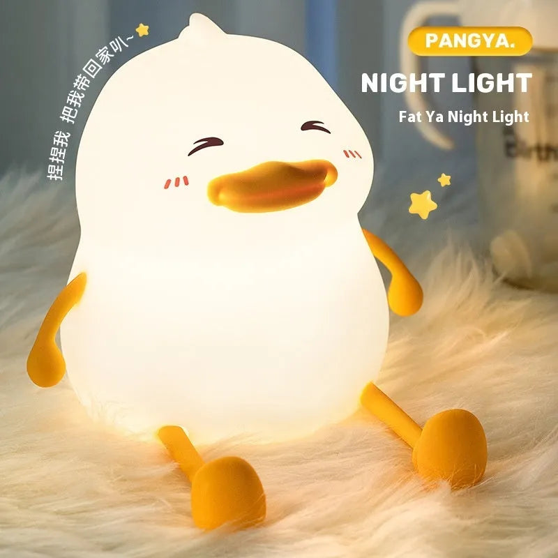 Chubby white USB rechargeable LED night light on a desktop, showing its compact size and soft glow.