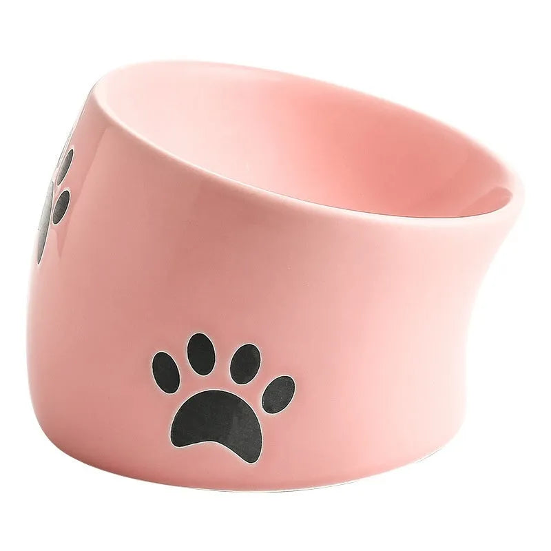 Ceramic cat food bowl with high foot base in a cat's paw print design