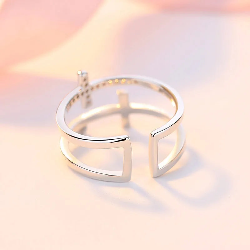 Double cross geometric women's ring with zircon stones on an adjustable copper band.
