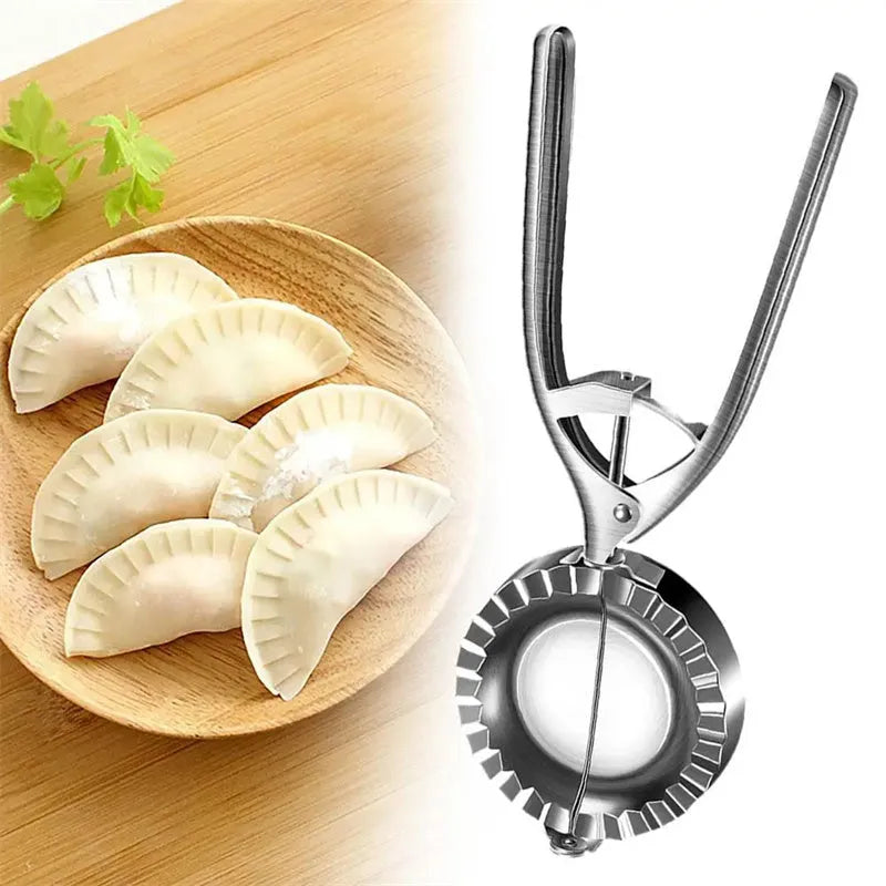 Silver stainless steel manual dumpling maker press tool on a kitchen surface.