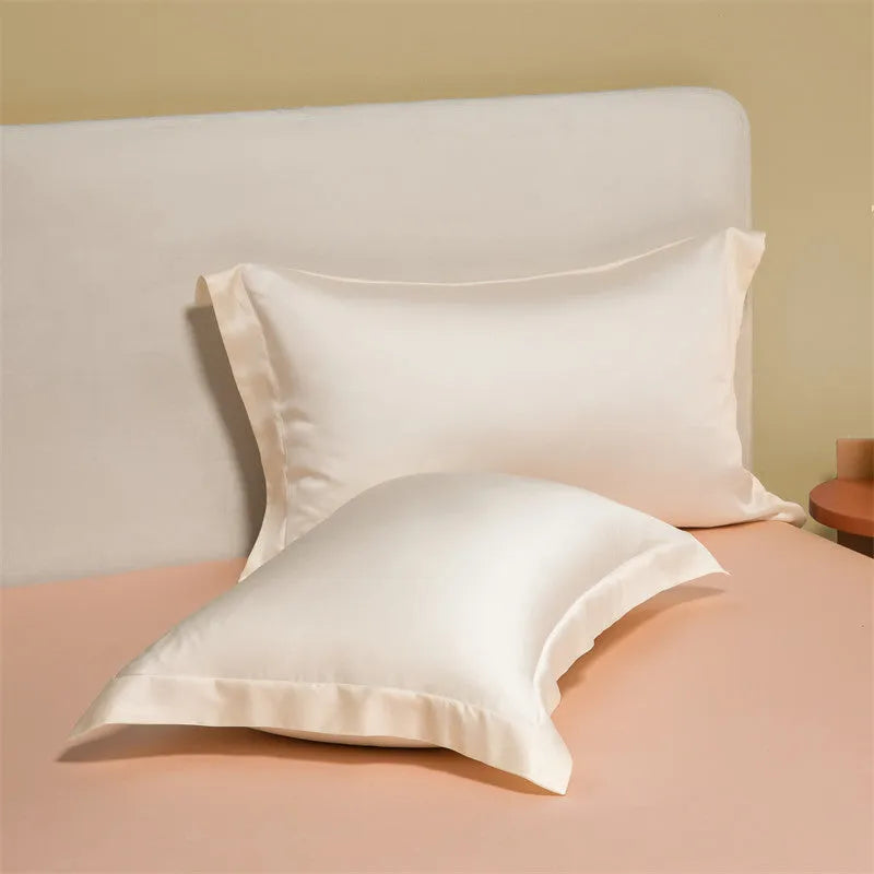 A neatly made bed with a Lenzing Tencel duvet cover and pillowcases in a soft grey colour.
