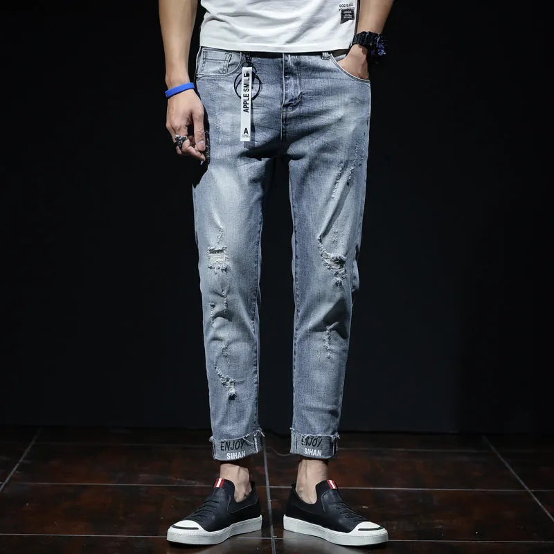 Light blue denim cropped jeans with ripped details on straight leg