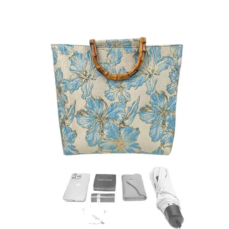 Light blue canvas shoulder bag with bronzing flower pattern, showing square shape and double shoulder straps