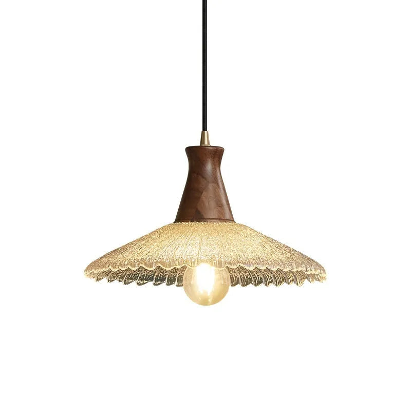 Retro chandelier with wooden body, brass metalwork, and a clear glass shade hanging from the ceiling.
