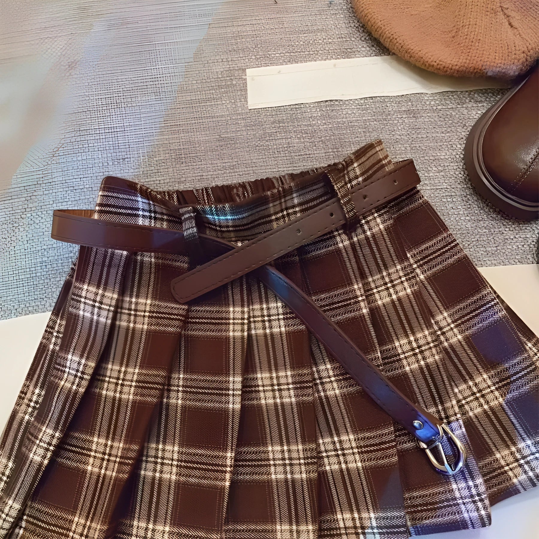 Girls' red and black plaid pleated A-line skirt made from cotton blend fabric.