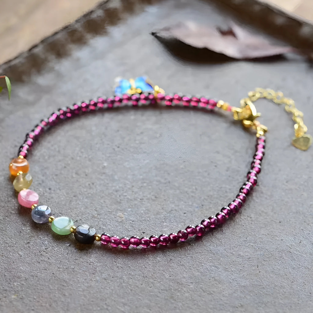 Close-up of a purple garnet anklet with a geometric design on a female ankle.