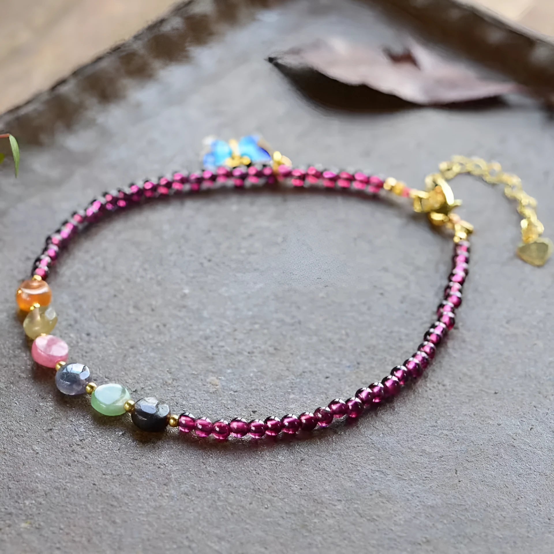 Close-up of a purple garnet anklet with a geometric design on a female ankle.