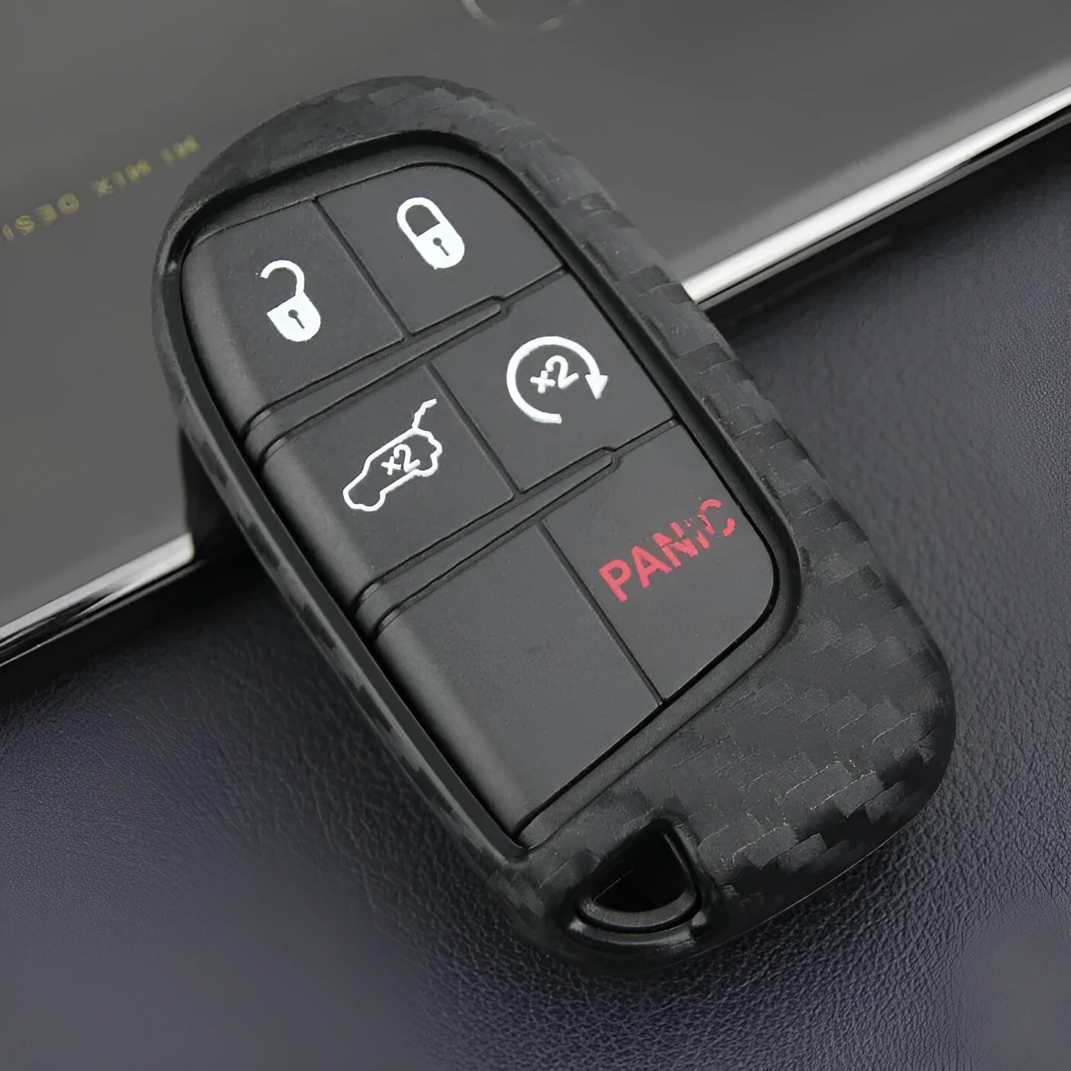 Black silicone protective case covering a Dodge car key fob, shown next to an unbuckled version.