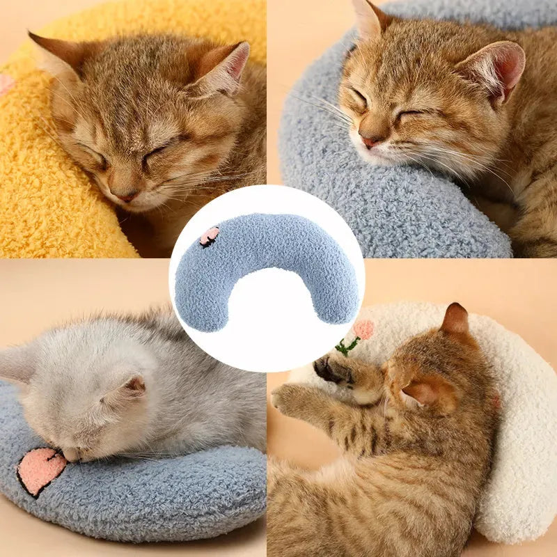 Small white U-shaped plush pillow for a cat or small dog, showing its half-donut shape with a raised rim.