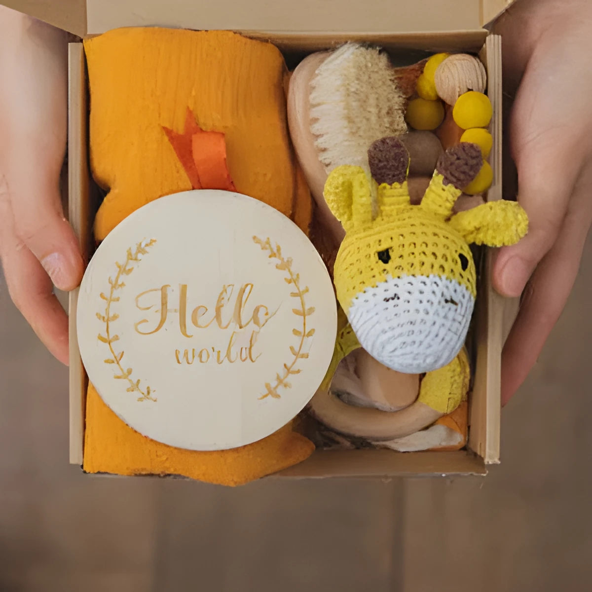 Baby teething toy gift set showing gauze blanket, wooden bell, gum teether, tire brush, and milestone on white background