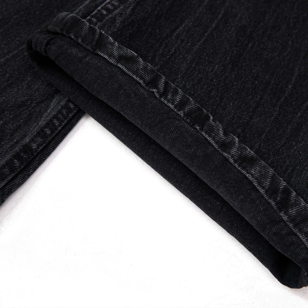 Men's black straight-leg jeans with a distressed lightning crack wash pattern on the legs.