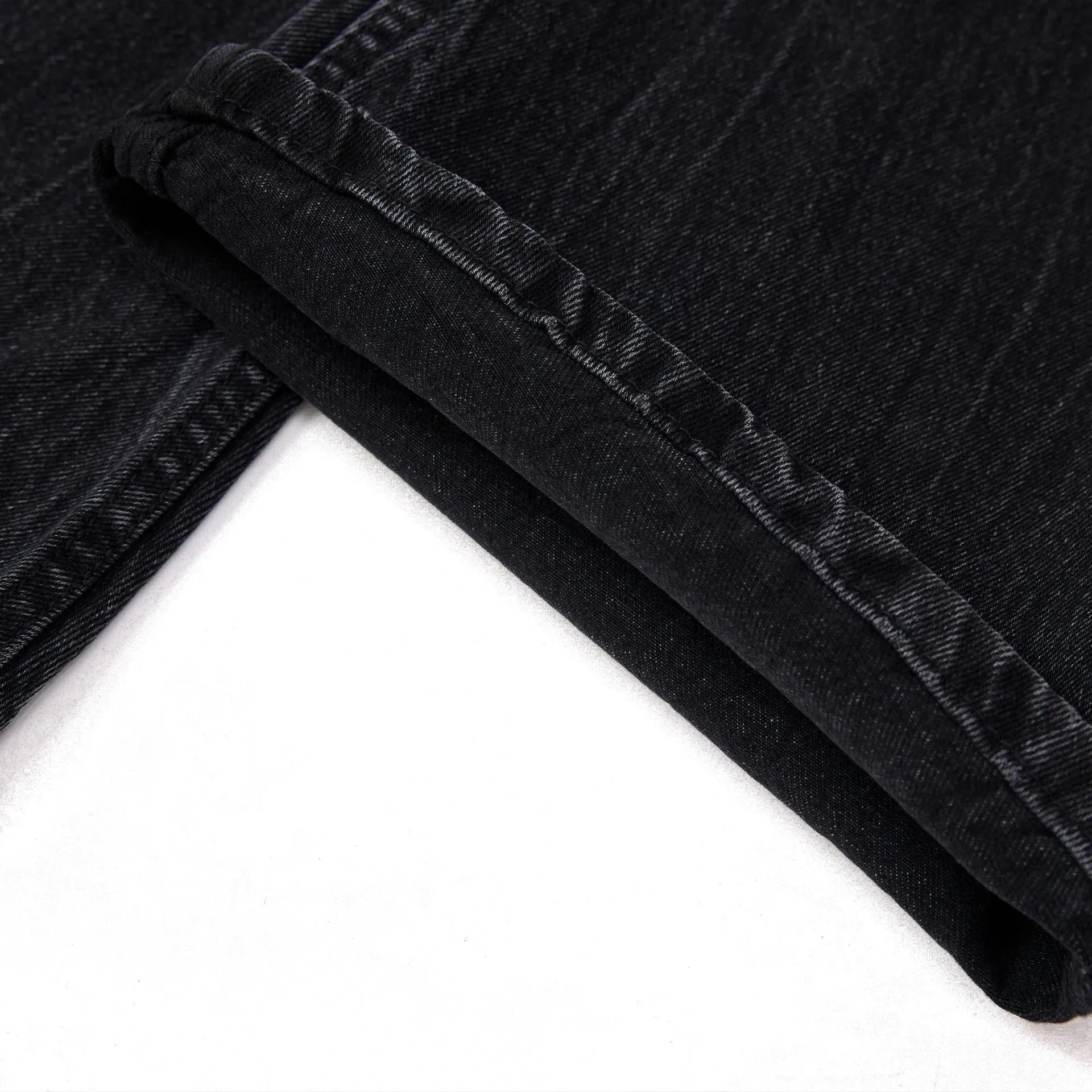 Men's black straight-leg jeans with a distressed lightning crack wash pattern on the legs.
