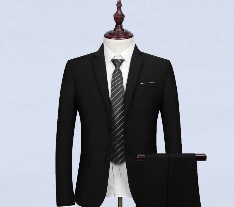 New men's slim fit black business suit set with 1-button jacket, waistcoat, shirt, and trousers on a hanger.