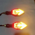 Arrow-shaped LED motorcycle turn signal light with 12V label and ABS plastic housing.