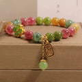 Natural colour tourmaline bracelet with four-leaf clover pearl pendant, geometric drop shape on woman's wrist.