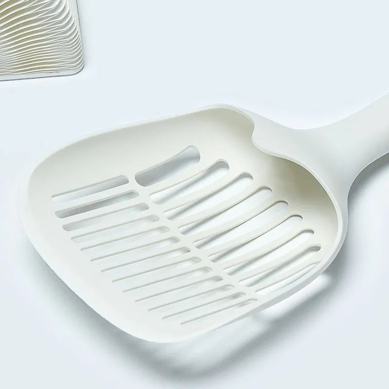 White plastic cat litter scoop with an attached storage base on a white background.