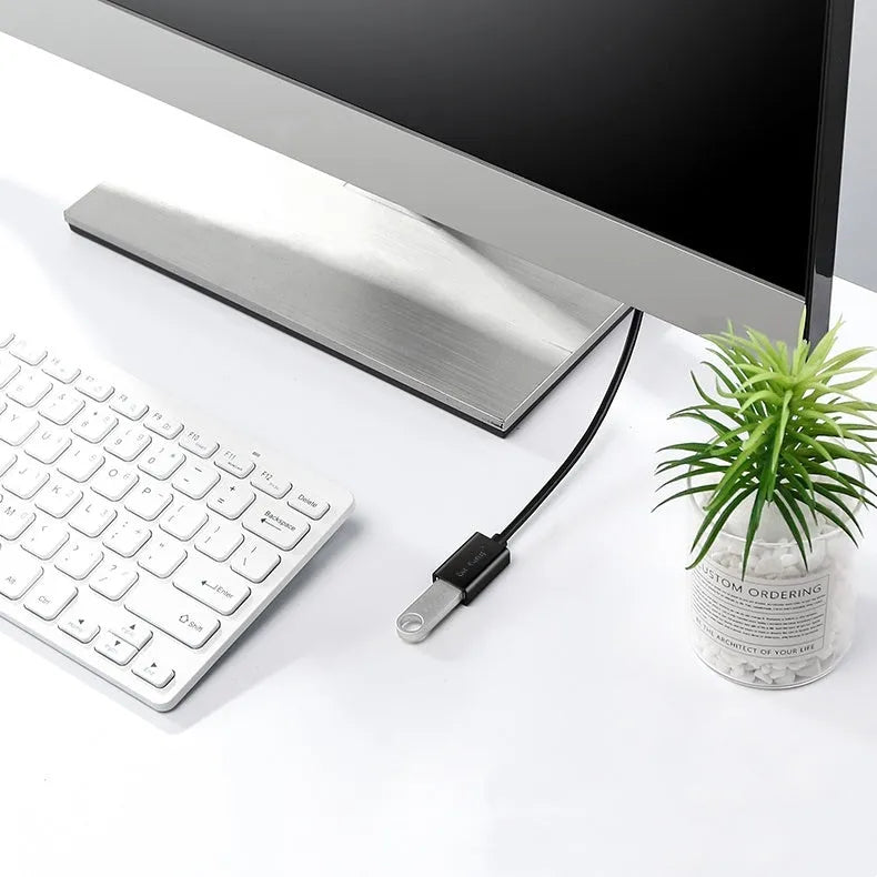 Black USB male to female extension cable on a desk, showing connector ends.