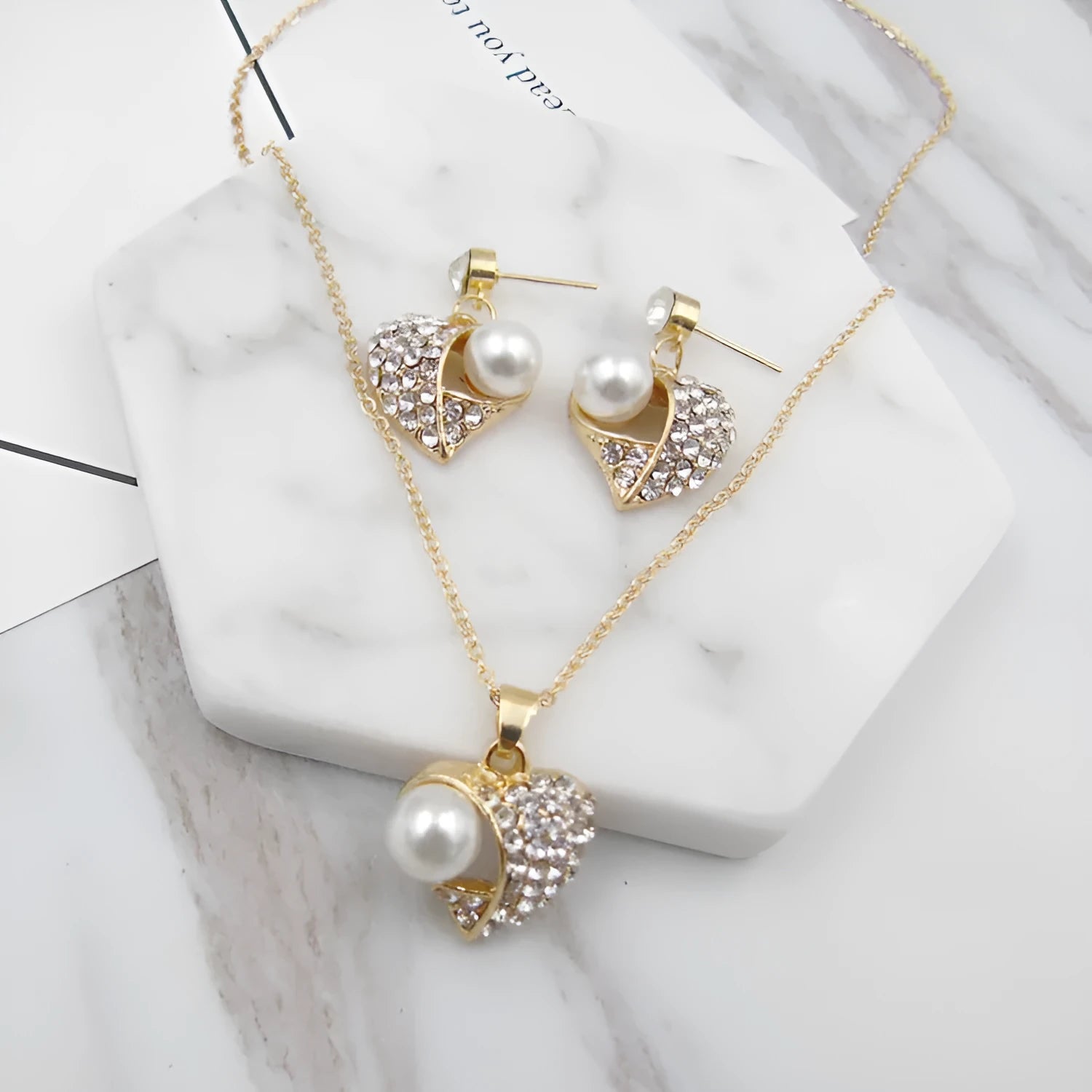 Gold heart pearl jewellery set with alloy necklace and earrings on display