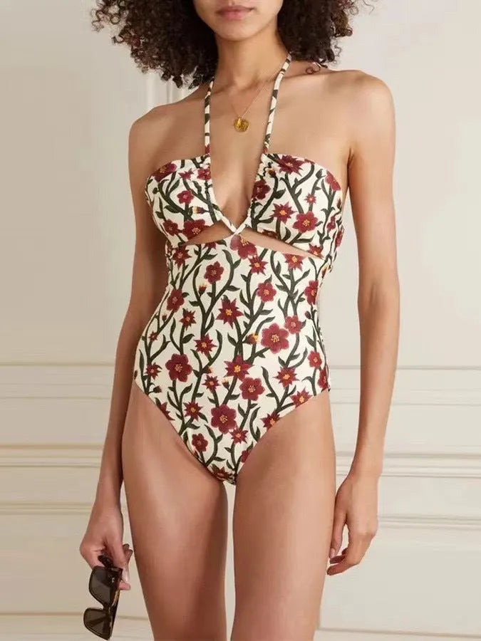 Female model wearing two-piece halter neck swimsuit with floral print and hollow-out gauze skirt cover-up