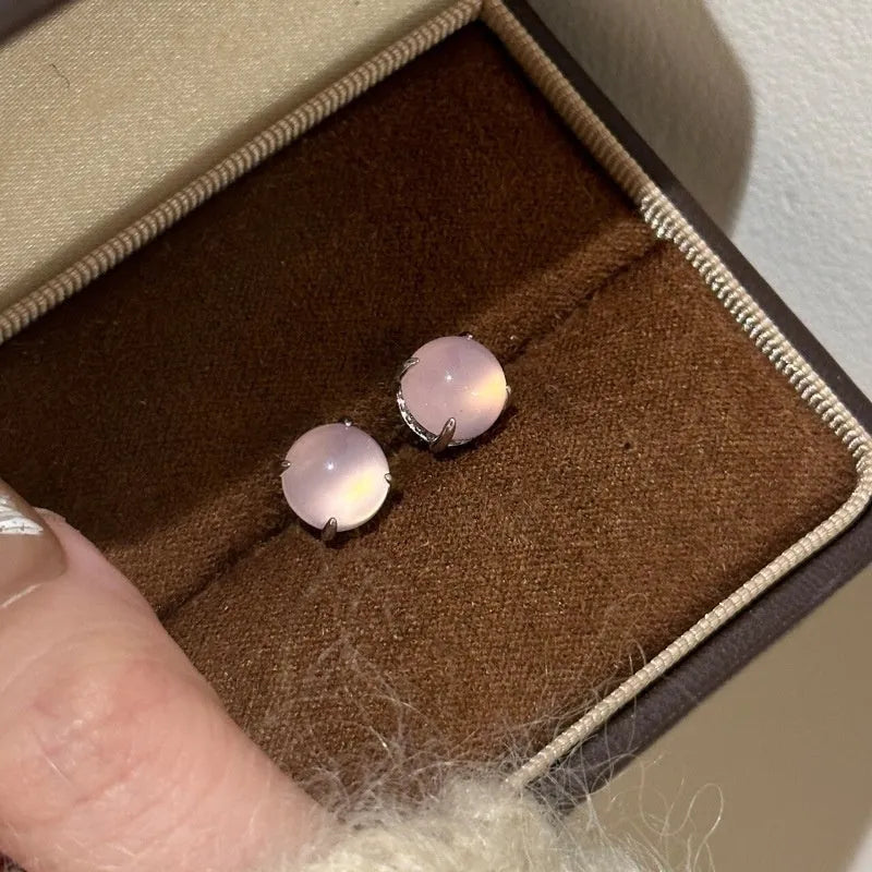 Chalcedony stud earrings with round egg surface design and four-claw settings in copper