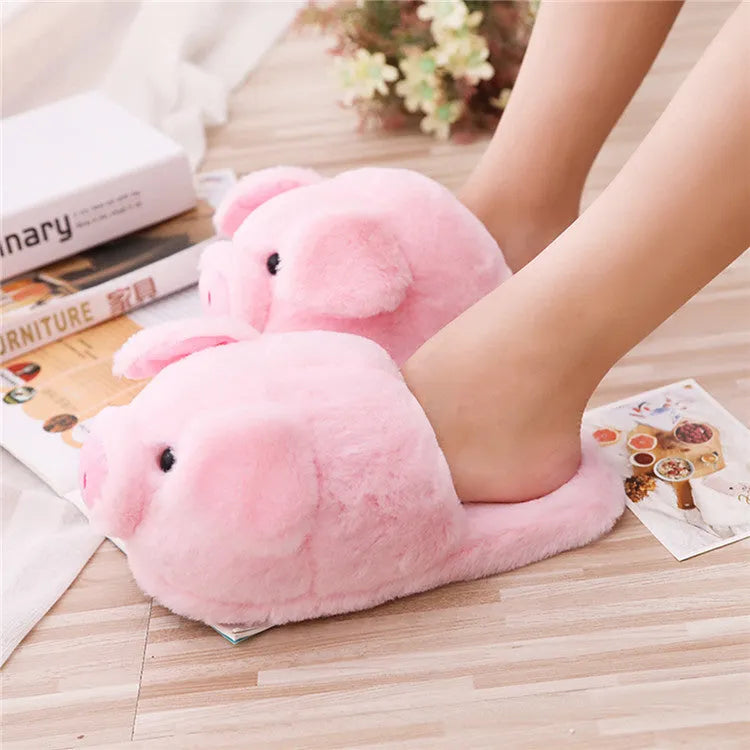 Pink pig-themed plush house slippers for adults on a plain background.