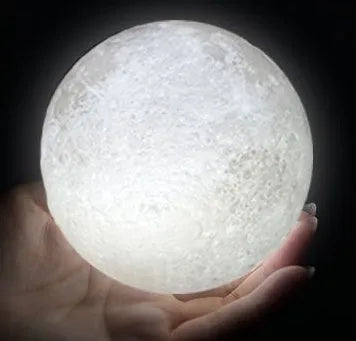 3D printed white moon lamp with detailed lunar surface texture on a wooden holder.