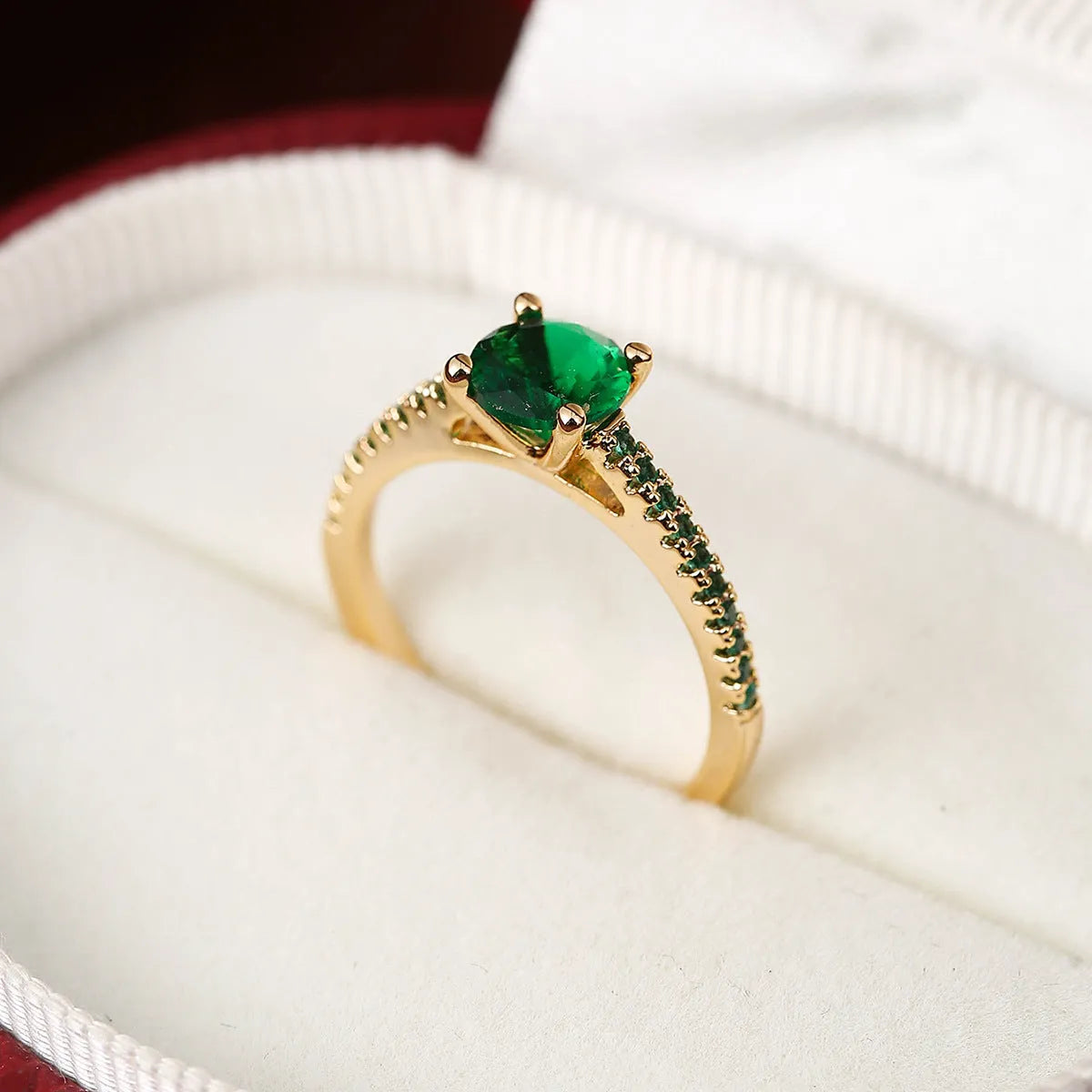 A hexagonal geometric ring with a zircon stone, shown in a gun black and rose red electroplated finish on a finger.
