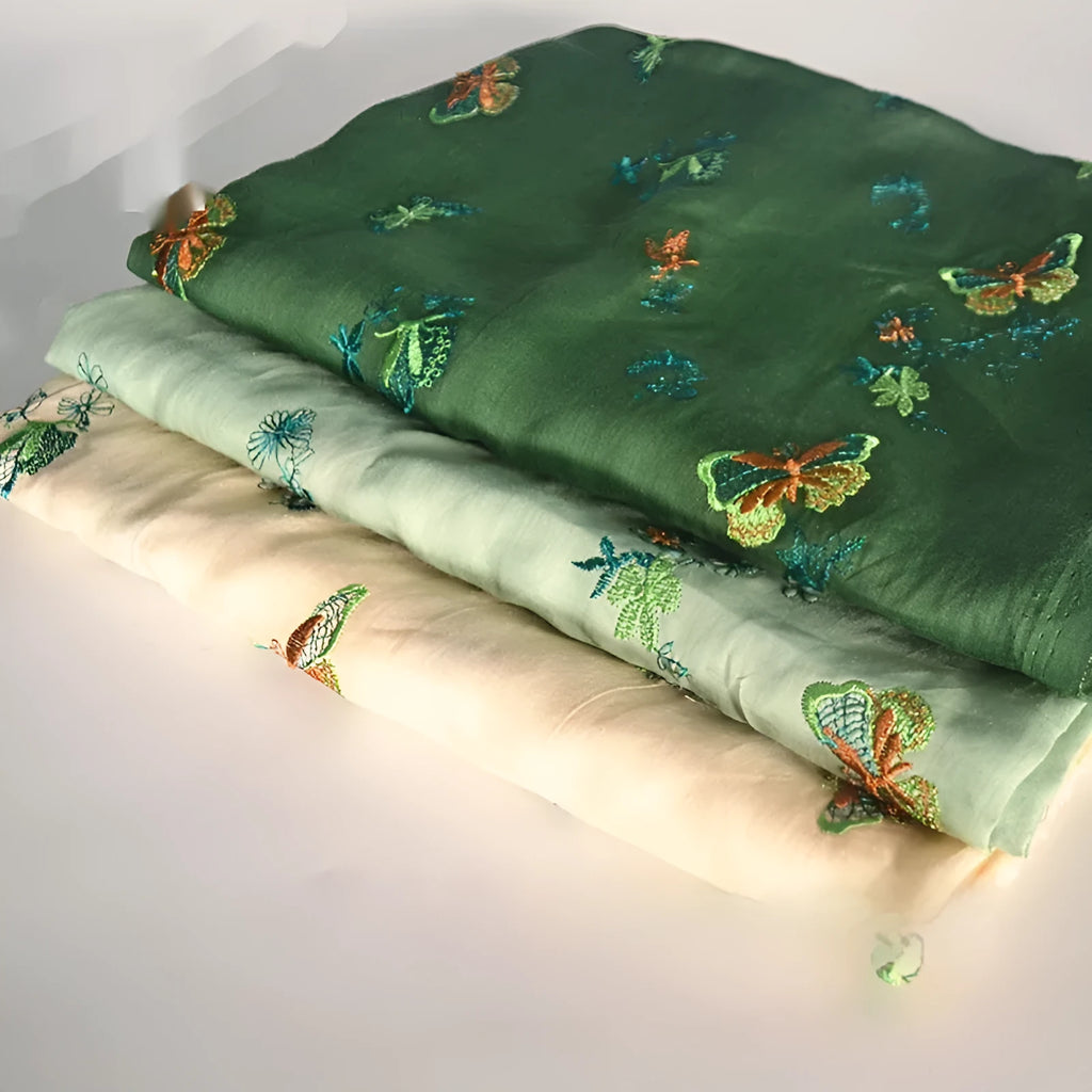 A piece of pure ramie embroidery fabric in a grass green colour, showing its woven texture.