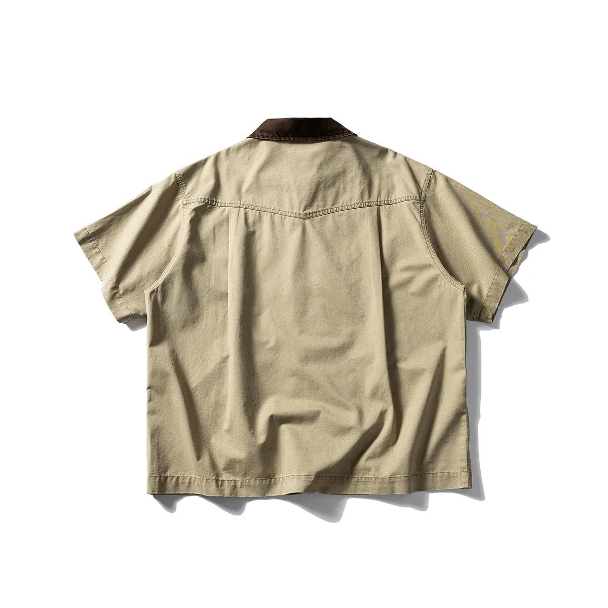 Washed grey cotton overalls shirt with short sleeves and a loose cardigan style on a hanger.