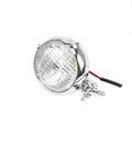 Black retro motorcycle headlight with aluminium housing and yellow halogen bulb.