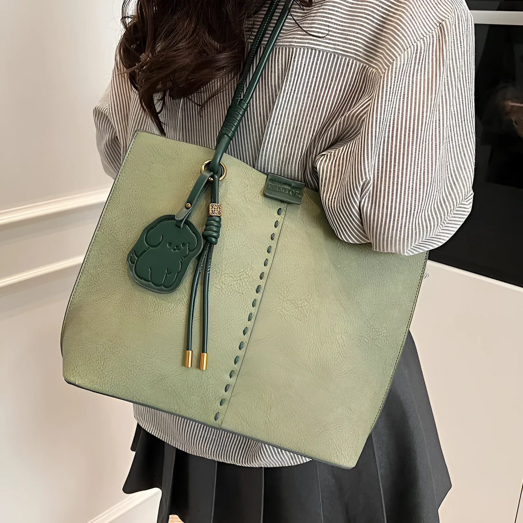 Green urban minimalist PU shoulder bag with stitching detail and double straps on a white background.