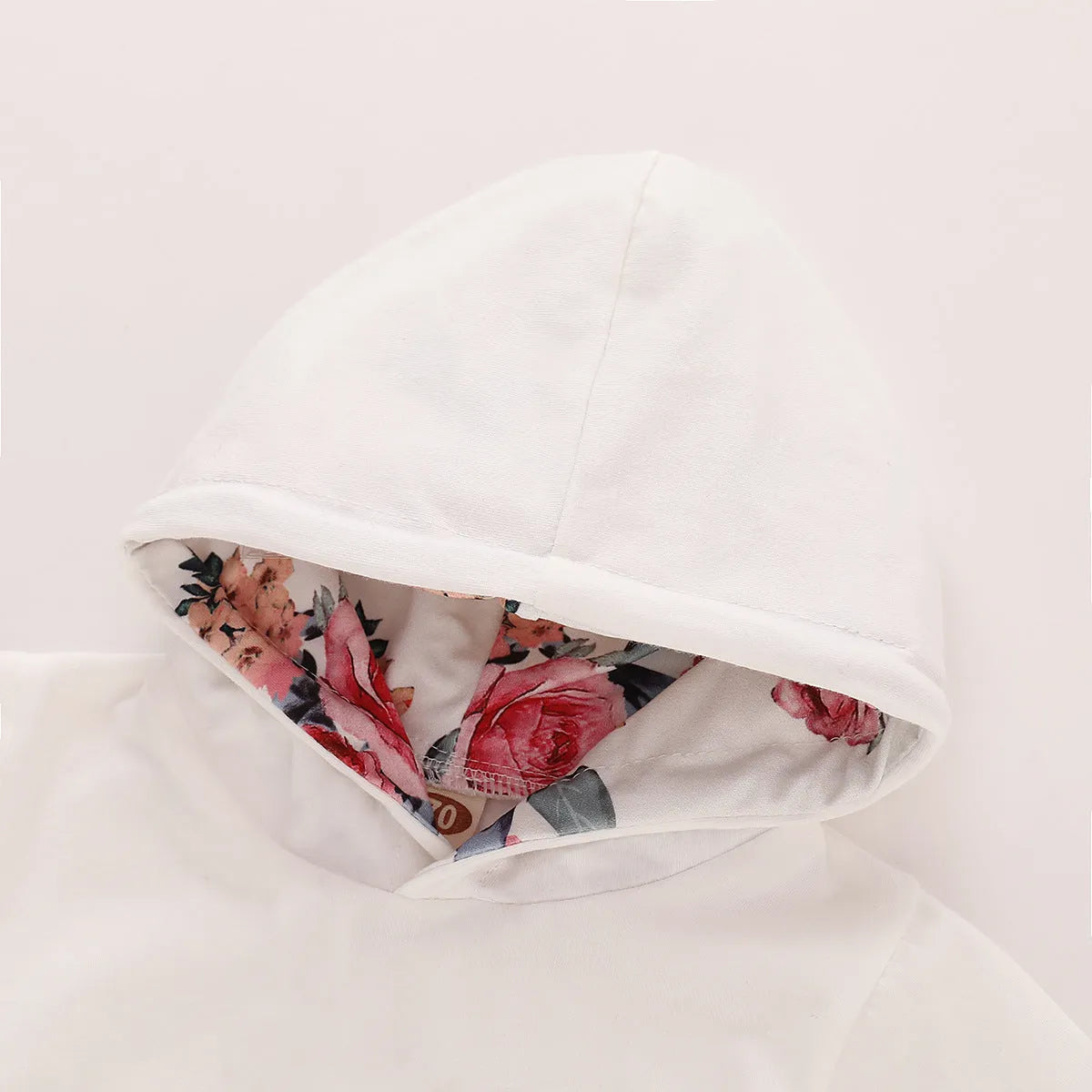 White cotton hooded romper suit for a baby girl with long sleeves and trouser legs.