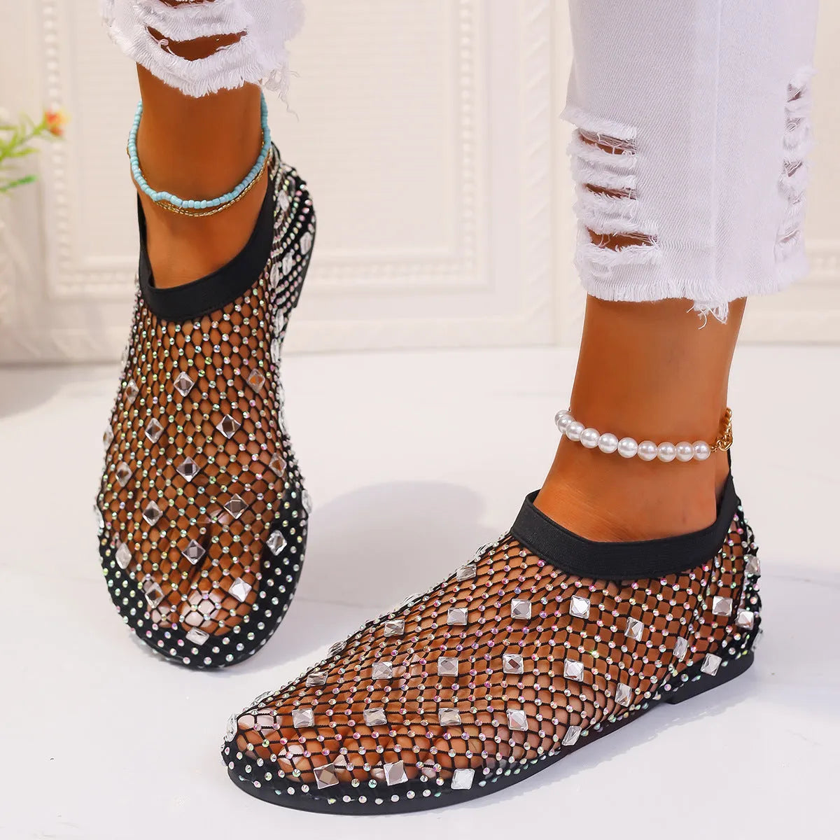 Women's flat sandals with a colourful rhinestone design on a breathable mesh upper and a rubber sole.