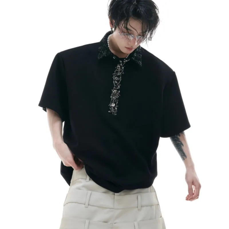 Man wearing a loose fit black polo shirt with a square collar and short sleeves.