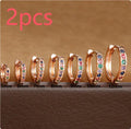 Gold, rose gold, and silver circle-shaped perforated stud earrings on a plain background.