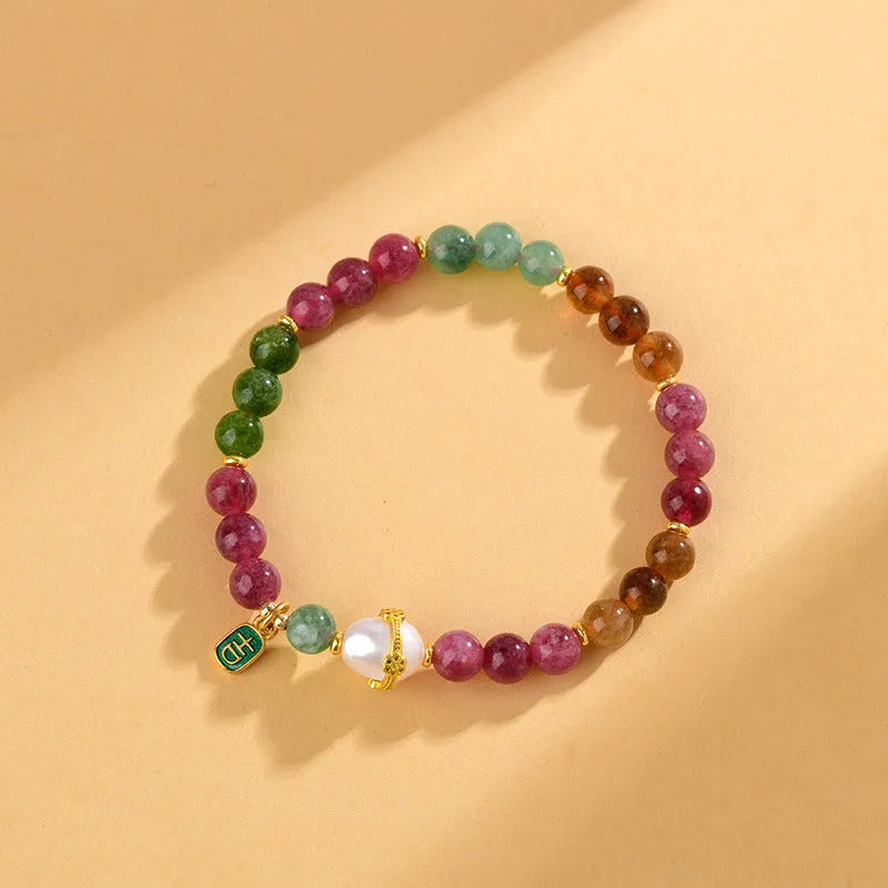 Geometric chalcedony stone bracelet with tourmaline colour beads on a wrist.