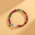Geometric chalcedony stone bracelet with tourmaline colour beads on a wrist.