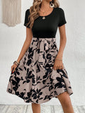 Women's khaki floral print A-line dress with lace-up shoulder straps on a hanger.