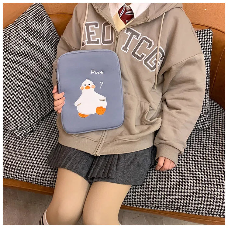 Blue cotton tablet case with embroidered cartoon duck design, showing zipper closure and protective frame.