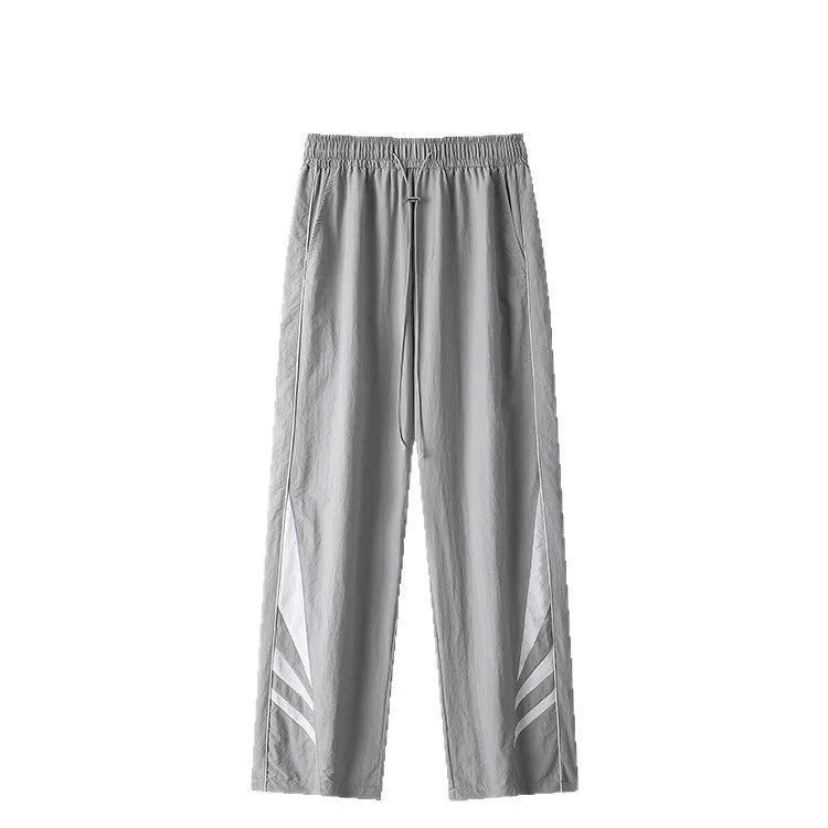 Men's straight leg trousers in black, showing button fly and elastic waistband on a hanger.